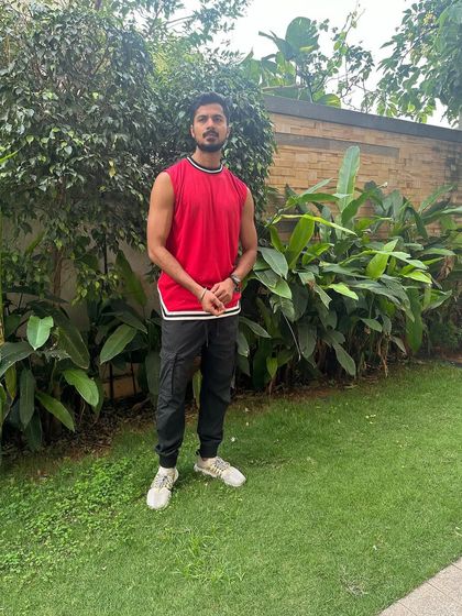 A full-length shot of my casual athletic outfit in a natural, green setting.