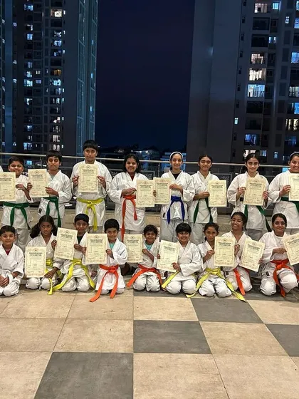 A large group of our students from the PFC and Purva Belmont dojos proudly display their new belts and certificates after a successful grading. We celebrate every step of the journey, together.