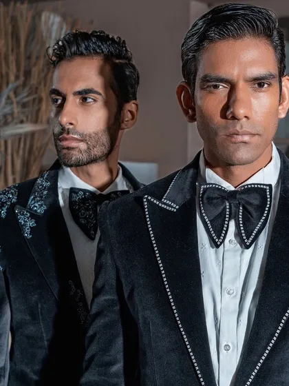 The artistry of our embellishments is on full display in this close-up. Notice the precise crystal detailing on the lapels and the unique, structured bow tie, elements that elevate a classic velvet tuxedo into a piece of wearable art.
