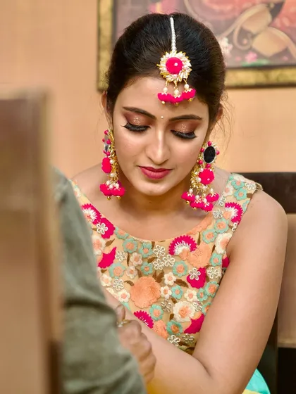 My client getting her mehendi done. The makeup is subtle and elegant, with a focus on glowing skin and defined eyes, ensuring she looks her best throughout the event.
