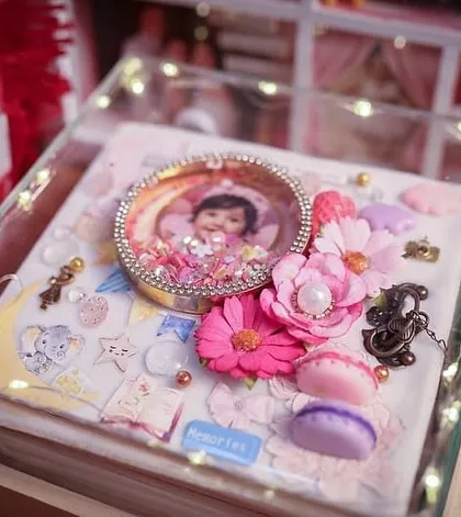 The finished album in its lit acrylic box, a treasure trove of memories ready to be cherished for a lifetime.