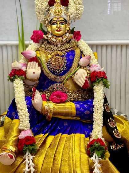 Goddess Lakshmi draped in a royal blue and gold Kanchipuram silk saree for the Varamahalakshmi festival, looking absolutely divine.