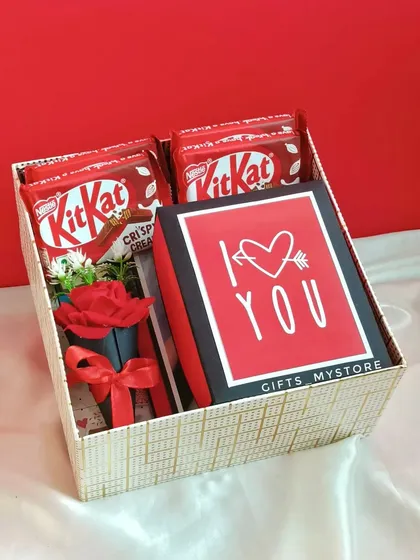 A small gift box from the "Sajni" hamper, containing KitKats and a mini rose bouquet.