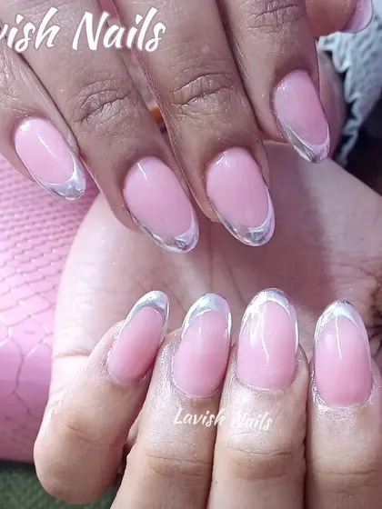 A sleek French manicure with a modern twist, featuring shiny silver chrome tips on oval nails.