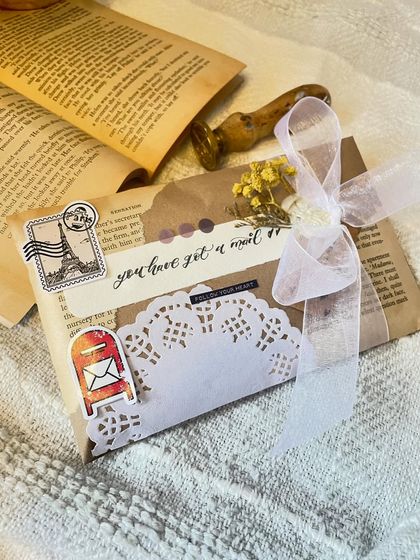 Another angle of this beautifully decorated envelope. The combination of vintage book paper, calligraphy, and delicate stickers creates a truly unique and personal touch for your handwritten note.