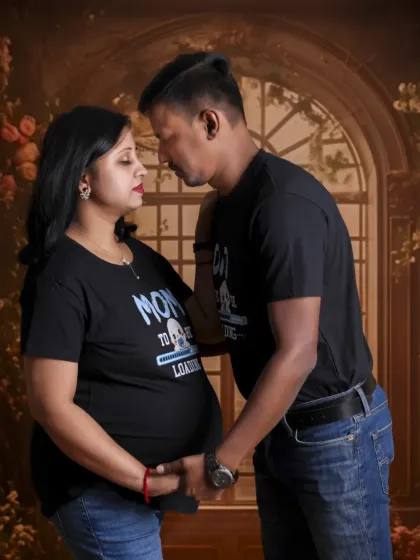An intimate gaze shared between the parents-to-be. Their casual, matching shirts make this a relatable and heartwarming portrait.