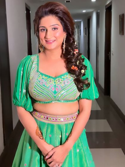 A soft, romantic side braid adorned with colorful flowers. This is a lovely choice for a Mehendi or Haldi function, adding a playful and festive touch.