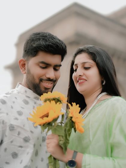 A close-up focusing on their interaction with the sunflowers, adding a sweet, romantic detail.