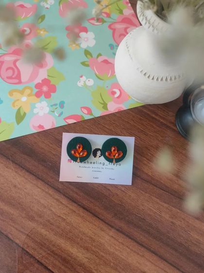 A collection of my simple and elegant fabric studs. Each pair is hand-painted with a small leaf motif and comes in a variety of colors like green, white, yellow, blue, and pink.