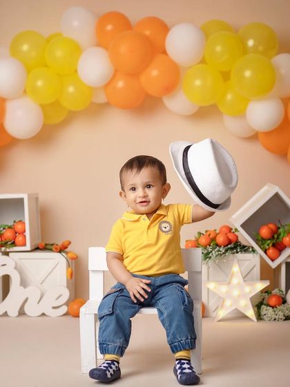Hats off, baby! This dapper little man is looking stylish in his orange-themed first birthday shoot.