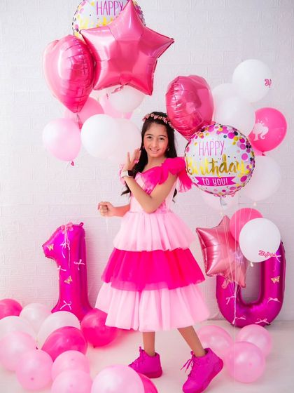 A stylish 10th birthday celebration. The balloon arrangement and the birthday girl's confident pose make this a fun and modern milestone portrait.