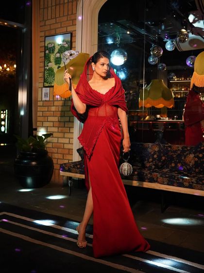The crimson slit gown seen in motion, a study in how structure and fluidity can coexist to create unapologetic glamour.