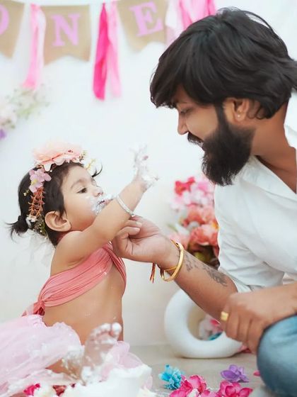 A sweet moment between father and daughter during her first birthday cake smash. It's a memory they'll both cherish when she's older.