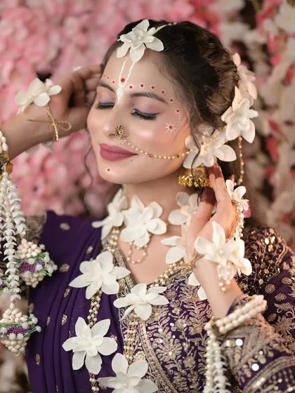 A serene and graceful pose from the Radha photoshoot, with soft lighting and a floral background.