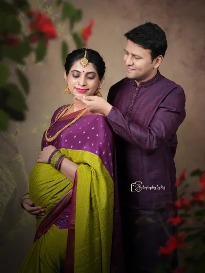 A romantic studio portrait of a couple in traditional attire, sharing a tender moment.