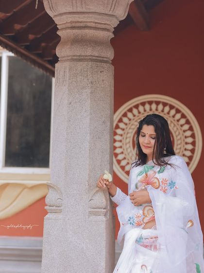 A series of peaceful portraits taken at a temple. The model's white saree contrasts beautifully with the intricate stone architecture, creating a sense of calm and serenity.