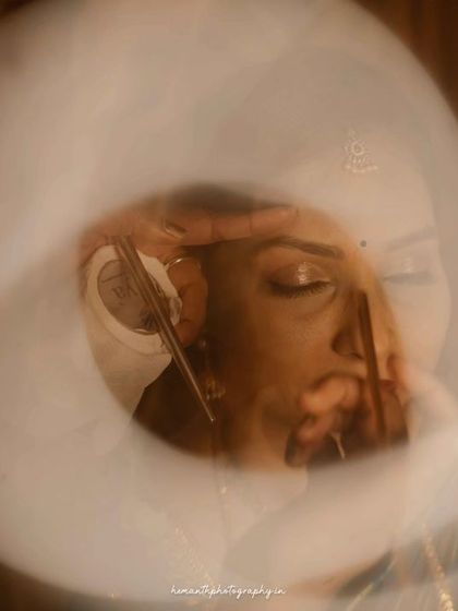 An artistic and abstract bridal portrait using a light ring to create a circular flare, focusing on the bride's eyes and makeup.