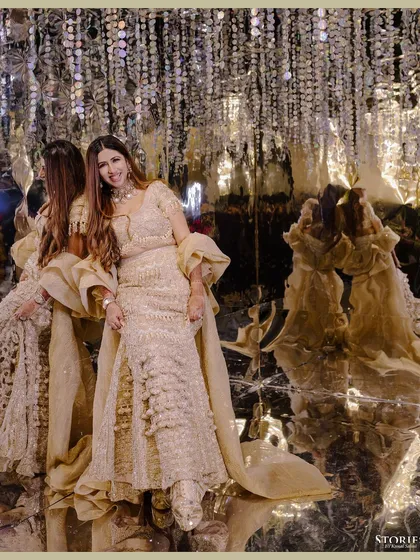 The bride posing against a wall of mirrors, her reflection creating an interesting and glamorous effect.