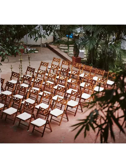 Intricately designed wooden chairs for guest seating, elevating the overall look of the garden ceremony.