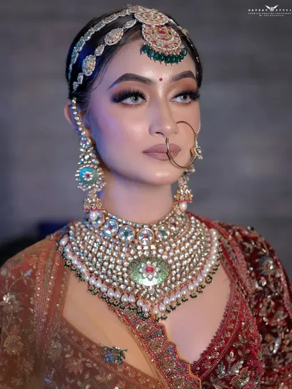 A striking close-up portrait, focusing on the magnificent layered necklace and flawless makeup.