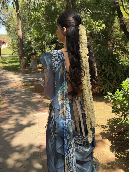 The back view, showing the beautiful hairstyle with a traditional gajra. The hair and makeup work together to create a cohesive and elegant look.