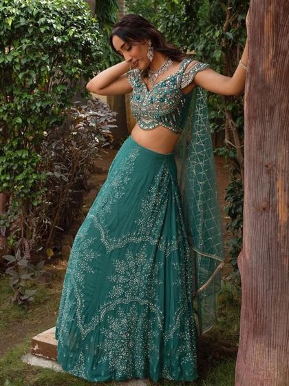 A candid shot of the teal green cape-sleeve lehenga, showing how beautifully it moves. This is a comfortable yet incredibly stylish rental option for any festive occasion.