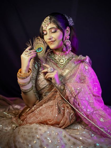 A creative pose with a peacock feather, adding a touch of artistry to the bridal portrait.