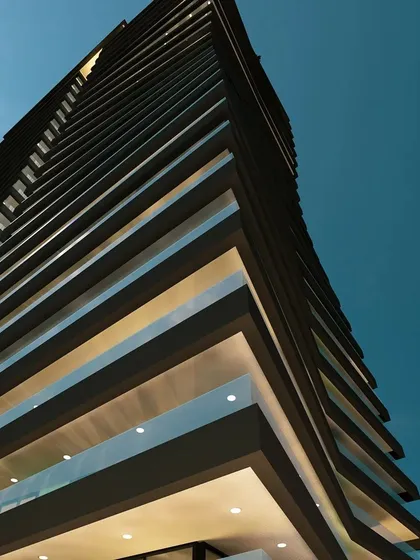A detail shot looking up at the Embrace Tower's facade. The rhythmic pattern of the balconies and the clean, straight lines of the interior structure create a powerful architectural statement.
