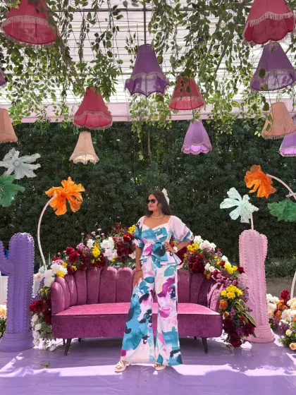 Posing at the vibrant, quirky, and colorful photo booth set up for the wedding carnival.