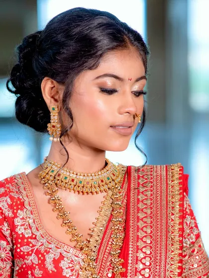 A close-up of the bride's makeup and elegant hair updo. The soft gold eyeshadow and defined liner make her eyes the star of the show.