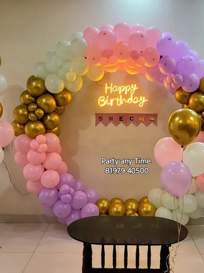 A simple pastel and gold circular balloon arch for a birthday party.