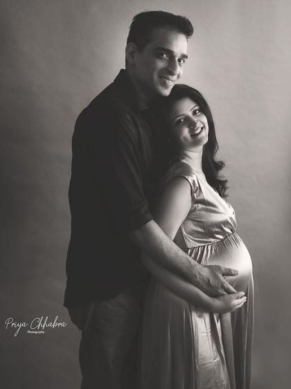 A joyful moment captured in black and white. The couple's genuine smiles and loving embrace make this a heartwarming and classic maternity portrait.