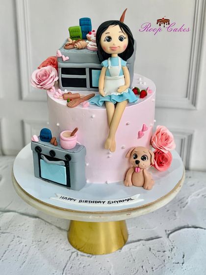 A cake for a baker. This fully edible, customized cake features a fondant figure of the birthday girl, surrounded by miniature ovens, mixing bowls, and even a cute puppy.