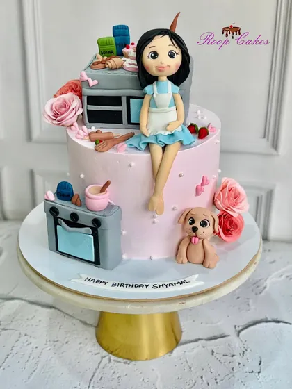 A fully edible custom cake for a baker's birthday. It features a fondant version of her in her kitchen, complete with a mini oven, baking tools, and her adorable pet dog.