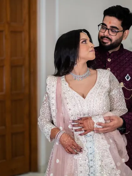 A classic portrait pose with a modern twist. The couple's elegant outfits and the clean lines of the background create a sophisticated look.