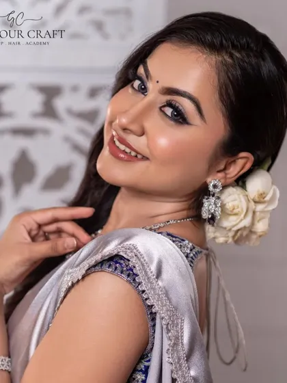 A beautiful smile completes this modern ethnic look. The silver saree and diamond jewelry are perfectly complemented by the model's radiant expression and the soft floral hair accessory.