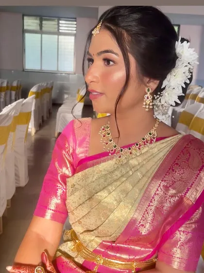 A side profile highlighting the intricate necklace and the clean, elegant hair and makeup.