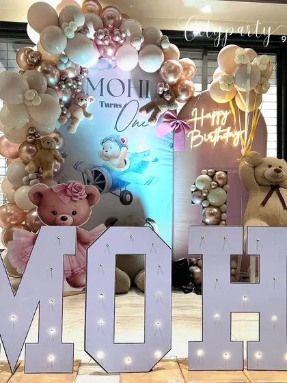 We also provide large, light-up marquee letters to spell out the birthday child's name. Here, the name 'MOHI' is featured in front of the teddy bear themed backdrop for a personalized touch.