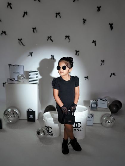 A spotlight effect highlights the older sister, making her the star of the show in this dramatic fashion portrait.