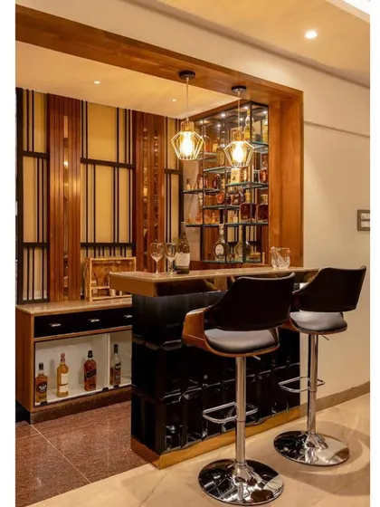 A sophisticated home bar designed for the modern connoisseur. The design features a dark wood and black color scheme, ample bottle storage, and comfortable bar stools for entertaining.