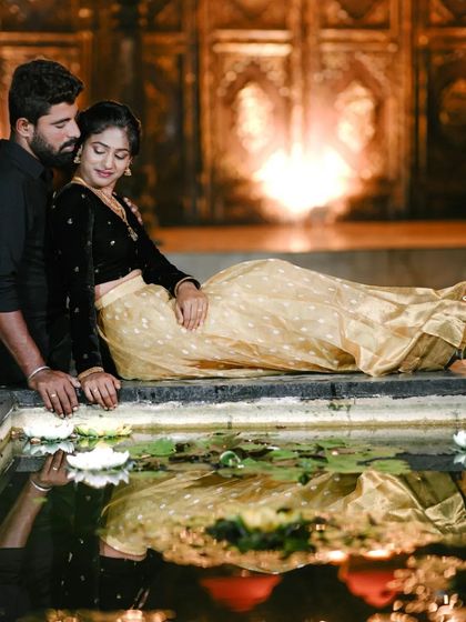 A beautiful reflection shot by the water, with the grand, lit-up doorway in the background.