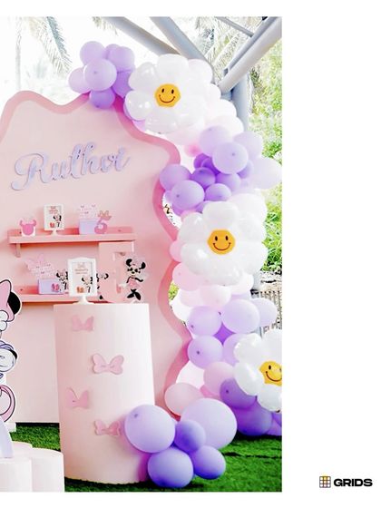 A cheerful balloon arch with smiley-faced daisy balloons, part of our Minnie and Daisy themed party decor.