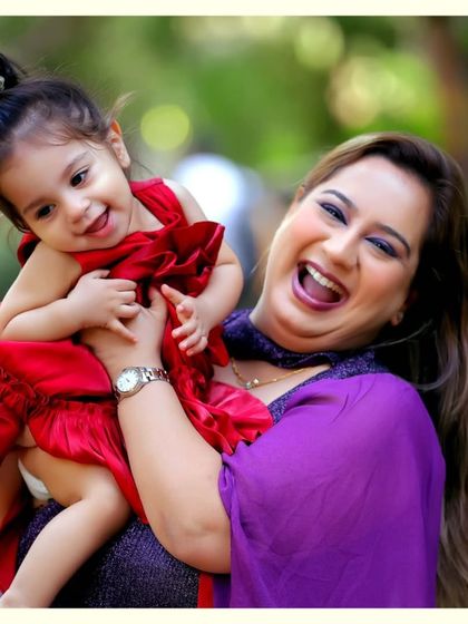 Pure happiness captured in a mother-daughter portrait. Her bright red dress and their shared laughter make this a vibrant and joyful image.
