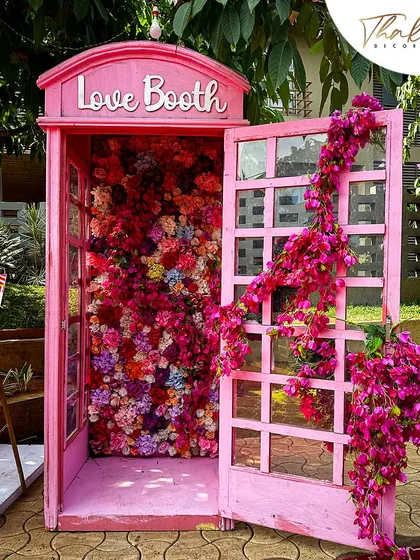 We create unique, Instagrammable moments for your guests. This vintage pink telephone booth, overflowing with a cascade of colorful flowers, served as a whimsical and highly popular photo opportunity.