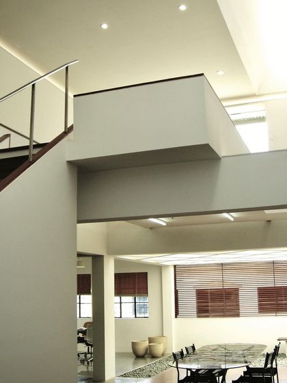 A view across the open-plan Zanav Home Studio, showing the different levels and work areas. The design uses changes in floor level and simple partitions to define zones within a larger, interconnected space.