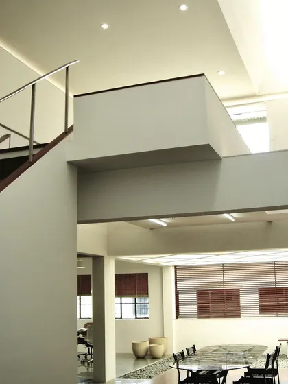 A view across the open-plan Zanav Home Studio, showing the different levels and work areas. The design uses changes in floor level and simple partitions to define zones within a larger, interconnected space.