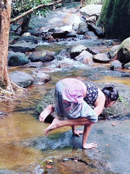 A moment of balance in Bakasana (Crow Pose) on a rock by the water. Nature is the ultimate yoga mat.