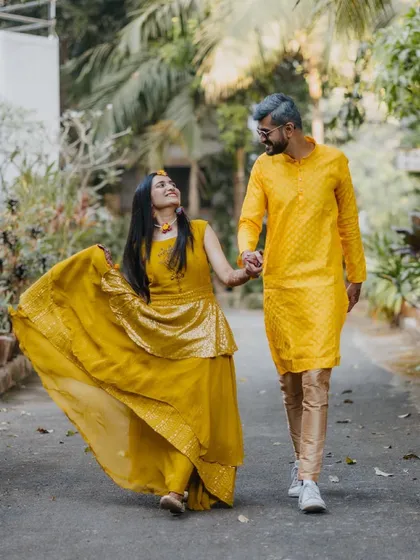 A bright and joyful shot from a Haldi ceremony. The couple, dressed in vibrant yellow, shares a happy walk, perfectly capturing the festive spirit of the event.