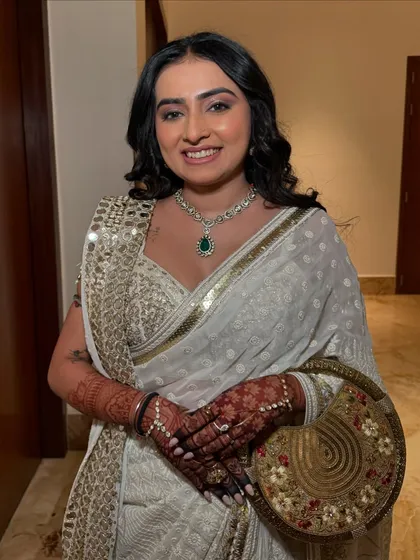 The complete look, with a beautiful mirror-work saree and an elegant, embroidered potli bag.