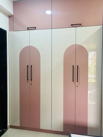 A closer view of the pink and white arch-patterned wardrobe doors.